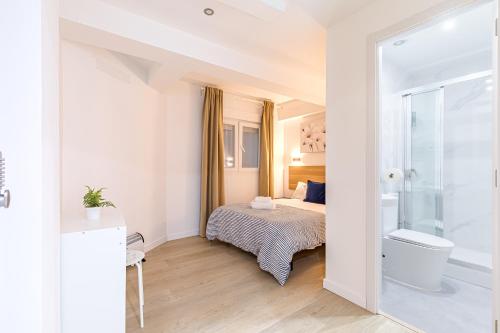 a small bedroom with a bed and a shower at LooP Alcala in Madrid