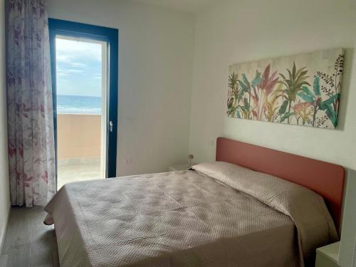 a bedroom with a bed and a view of the ocean at Casa Aniste in Castelsardo
