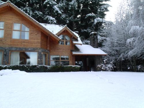 a house with snow on the ground in front of it at Cabañas Rincon del Lago in Villa La Angostura