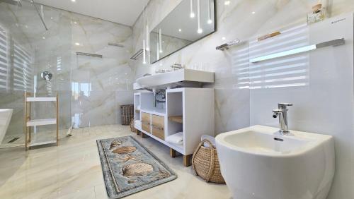 a bathroom with a sink and a toilet in it at Ashore - Beachfront Paradise in St. Helena Bay