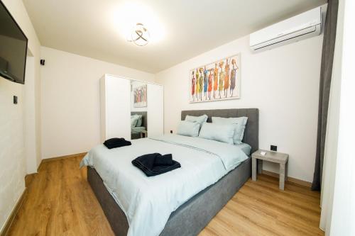 a bedroom with a large bed and a television at Еlite central stay apartment in Pleven