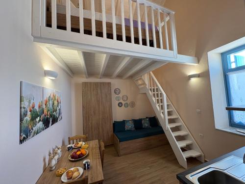 a living room with a loft bed and a dining room at Aleminas Rooms 2 in Symi