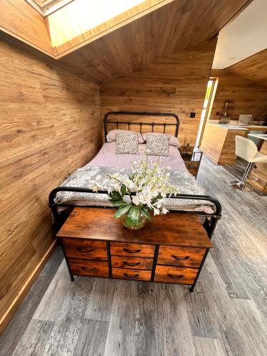 a bedroom with a bed and a table with flowers on it at The Loft in Burnley