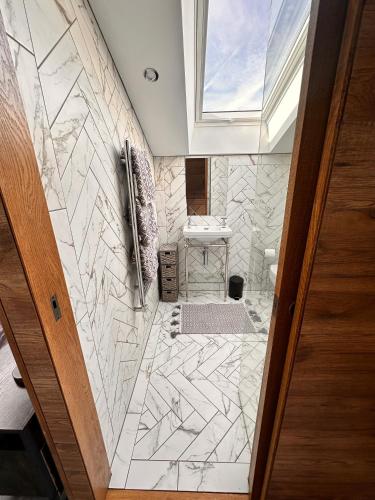 a bathroom with a marble tile floor and a window at The Loft in Burnley