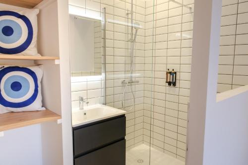 a bathroom with a sink and a shower at Les Suites du Parc - Elégance et lumière face au Parc Simone Veil appartement 2 chambres à 2 minutes des halles in Sète