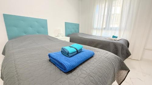 a blue suitcase sitting on a bed in a bedroom at Caballero in Torrevieja