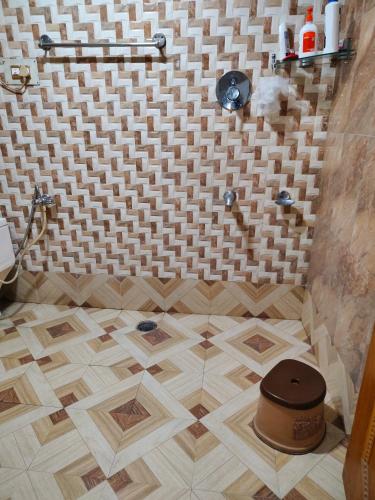 a bathroom with a tiled floor with a shower at Minnat Home Stay in Srinagar