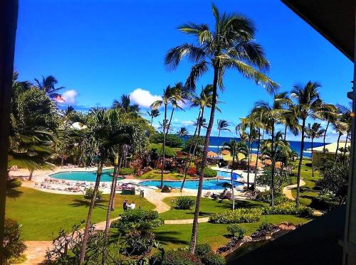 a view of a resort with palm trees and a pool at 2417 at Oceanfront Resort Lihue Kauai Beach Drive Private Condo in Lihue
