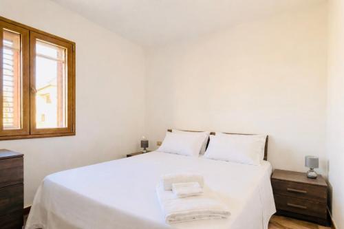 a bedroom with a white bed with two towels on it at Lucia House in Santa Lucia