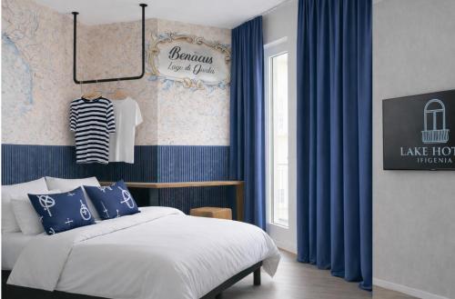 ein Schlafzimmer mit einem Bett, blauen Vorhängen und einem Fenster in der Unterkunft Lake Hotel Ifigenia in Nago-Torbole