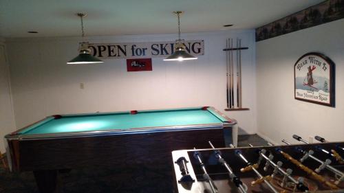 a pool table in a room with a sign for skiing at Val Roc Motel - Killington in Killington