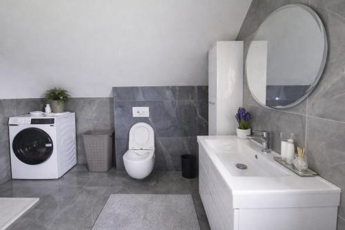 a bathroom with a washing machine and a sink at Plitvice Harmony one - seven person in Smoljanac
