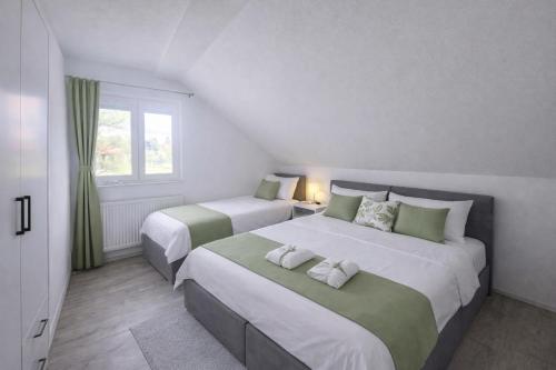 a bedroom with two beds and a window at Plitvice Harmony one - seven person in Smoljanac