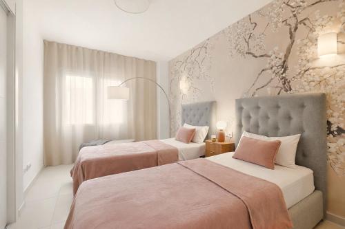 two beds in a hotel room with pink sheets at Apartment Grape Panorama Mar Punta Prima in Punta Prima