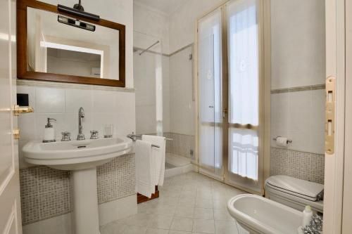 a white bathroom with a sink and a toilet at B&B Residence il Ciliegio , Via Villa Superiore 93 Luzzara in Luzzara