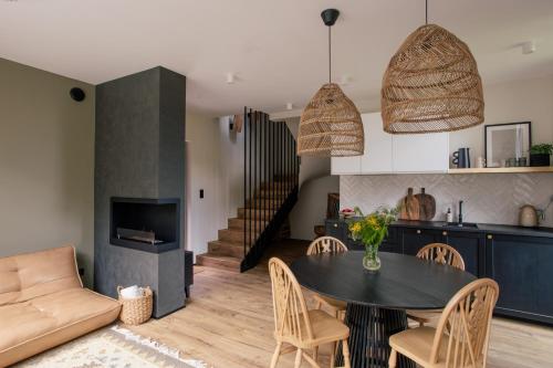 a kitchen and living room with a table and chairs at Chalets by Slow Tatry Boutique Resort&SPA in Zakopane