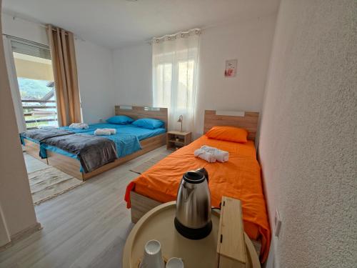 a bedroom with two beds and a table with a table sidx sidx sidx at Lone Star Apartments in Gusinje