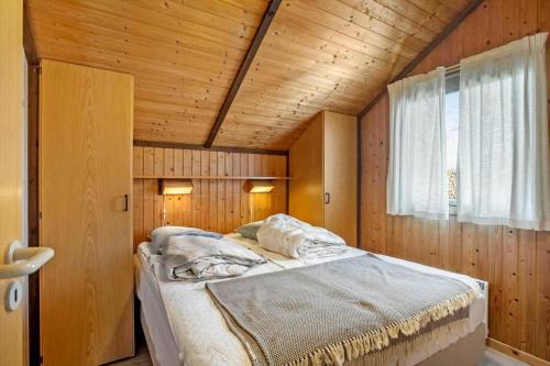 a bed in a room with a wooden ceiling at M412-Stubbekobing-Birkehegnet-28 in Stubbekøbing