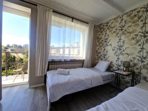 a bedroom with two beds and a large window at Promień 4 by Zen4Guest - Biskupin in Wrocław