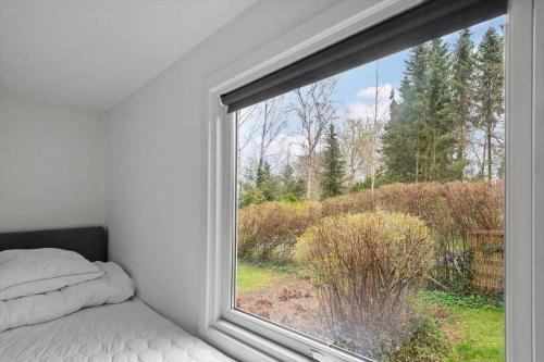 a bedroom with a window looking out at a field at S745-Stroby-Garderhojen-35 in Strøby