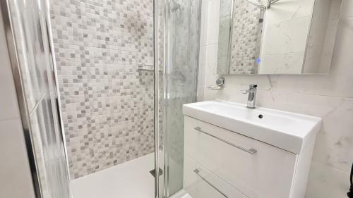 a white bathroom with a sink and a shower at Caballero in Torrevieja