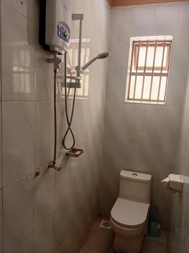 a small bathroom with a toilet and a shower at Uhuru 50 Hotel in Kasese