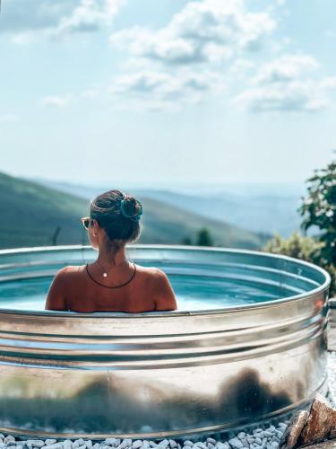 a woman sitting in a hot tub at Refúgio das Carquejas in Mondim de Basto