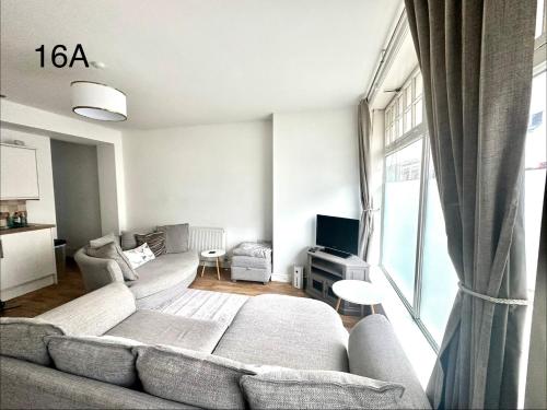 a living room with a couch and a tv at Dorchester Town Centre Entire Apartment in Dorchester