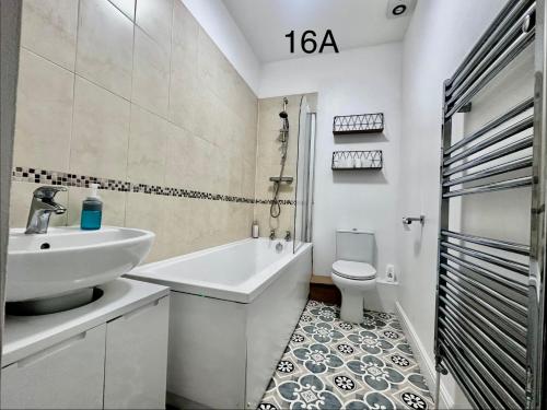 a white bathroom with a sink and a toilet at Dorchester Town Centre Entire Apartment in Dorchester