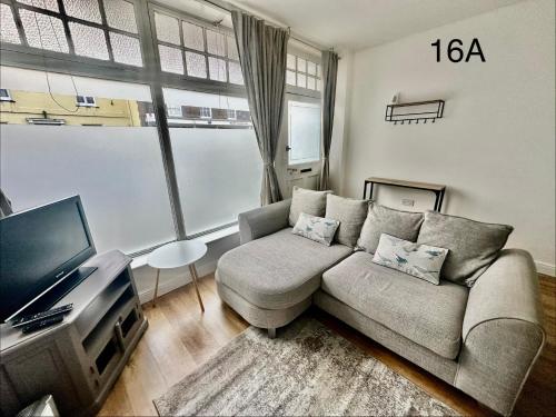 a living room with a couch and a tv at Dorchester Town Centre Entire Apartment in Dorchester
