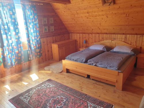 a bedroom with a bed in a log cabin at Chalupa 58 in Štiavnické Bane