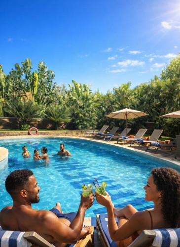 a man and woman sitting in chairs in a swimming pool at Mahafaly Hotel & Resort in Antsirabe
