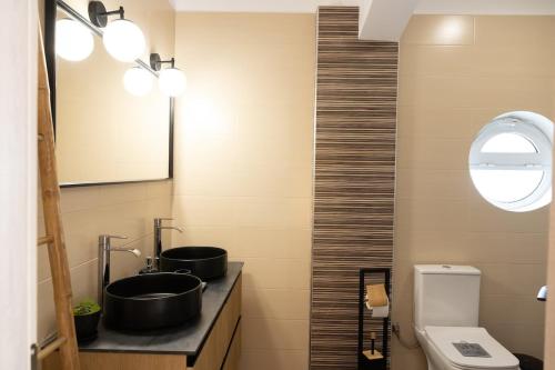 a bathroom with two sinks and a toilet at House on the Hill in Anavyssos