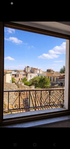 a window view of a city from a balcony at Le Arcada - Appartamenti diffusi nel cuore del centro storico di Orosei in Orosei