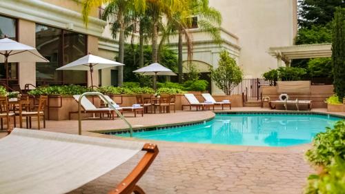 a swimming pool with chairs and tables and umbrellas at Grand Hotel in Sunnyvale