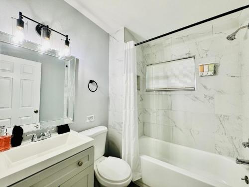 a bathroom with a sink and a toilet and a tub at Lakeland Retreat King Bed Pet Friendly Yard in Lakeland