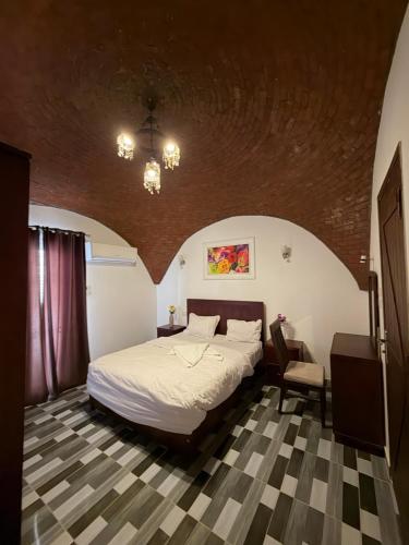 a bedroom with a bed and a table and a chair at KR Hotel in Luxor