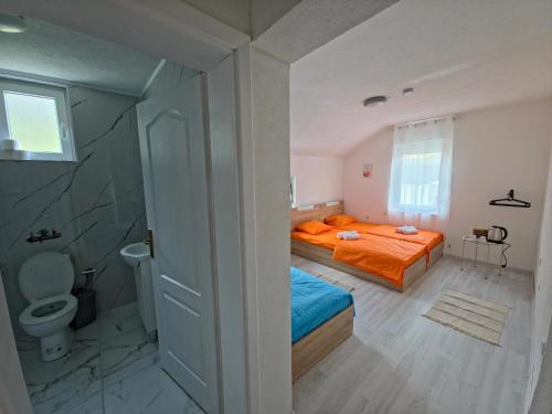 a small bedroom with a bed and a toilet at Lone Star Apartments in Gusinje