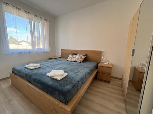 a bedroom with a bed with two towels on it at KutyaGazdi Apartman in Balatonfenyves
