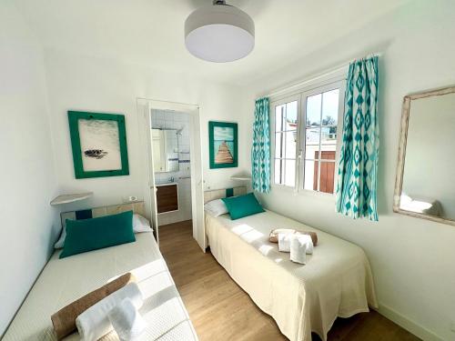 a room with two beds and a window at Santa Brígida in Cala en Porter