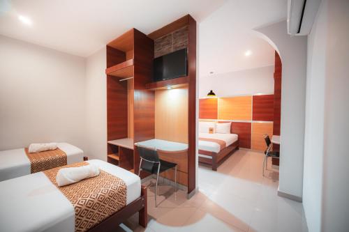 a hotel room with two beds and a desk at Hotel Nilas in Tarapoto