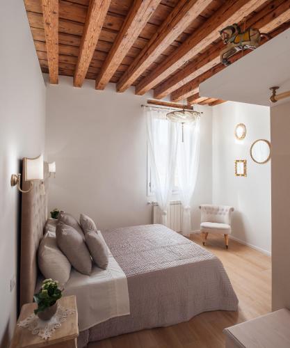 a bedroom with white walls and a bed with pillows at Ca del Mar Venice Luxury Apartments in Venice