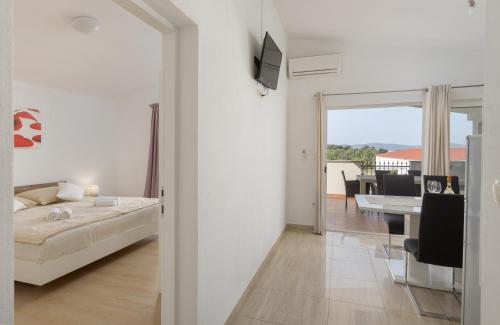 a bedroom with a bed and a dining room at Peacefull Apartment with Garden and Barbeque in Biograd na Moru