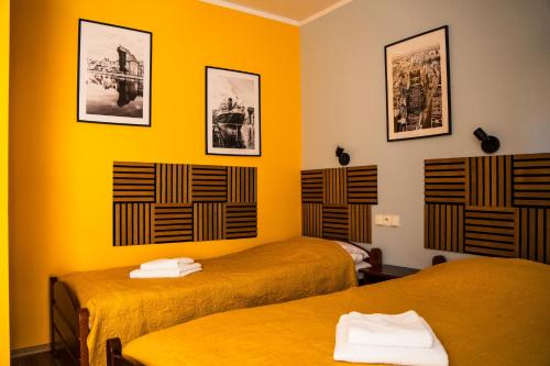two beds in a room with yellow walls at Willa Bliska in Gdańsk
