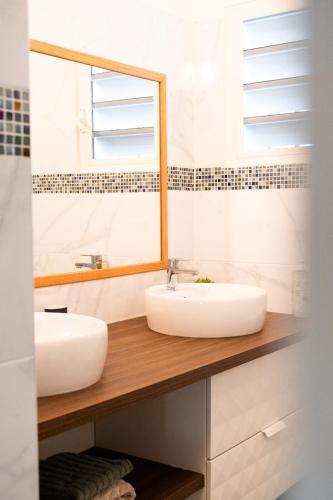 a bathroom with two sinks and a mirror at Quiet loft studio - Pinel side in Cul de Sac