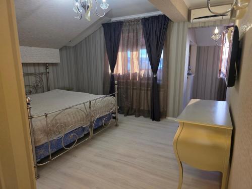a bedroom with a bed and a table and a window at Boutique Apartment with Jacuzzi Pleven in Pleven