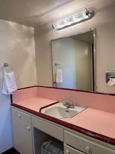 a bathroom with a sink and a mirror at Crystal Motel in Red Bluff