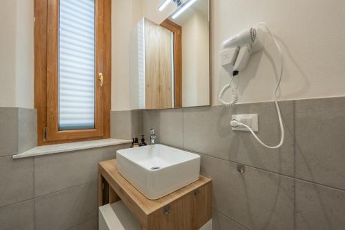 a bathroom with a white sink and a mirror at LORENZO APPARTAMENTO Borgo Giannotti in Lucca