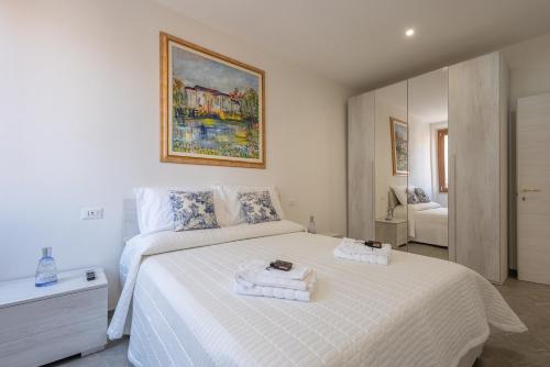 a bedroom with a white bed with towels on it at LORENZO APPARTAMENTO Borgo Giannotti in Lucca