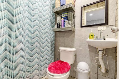 a bathroom with a white toilet and a sink at Caribbean apartment in private area in Cancún